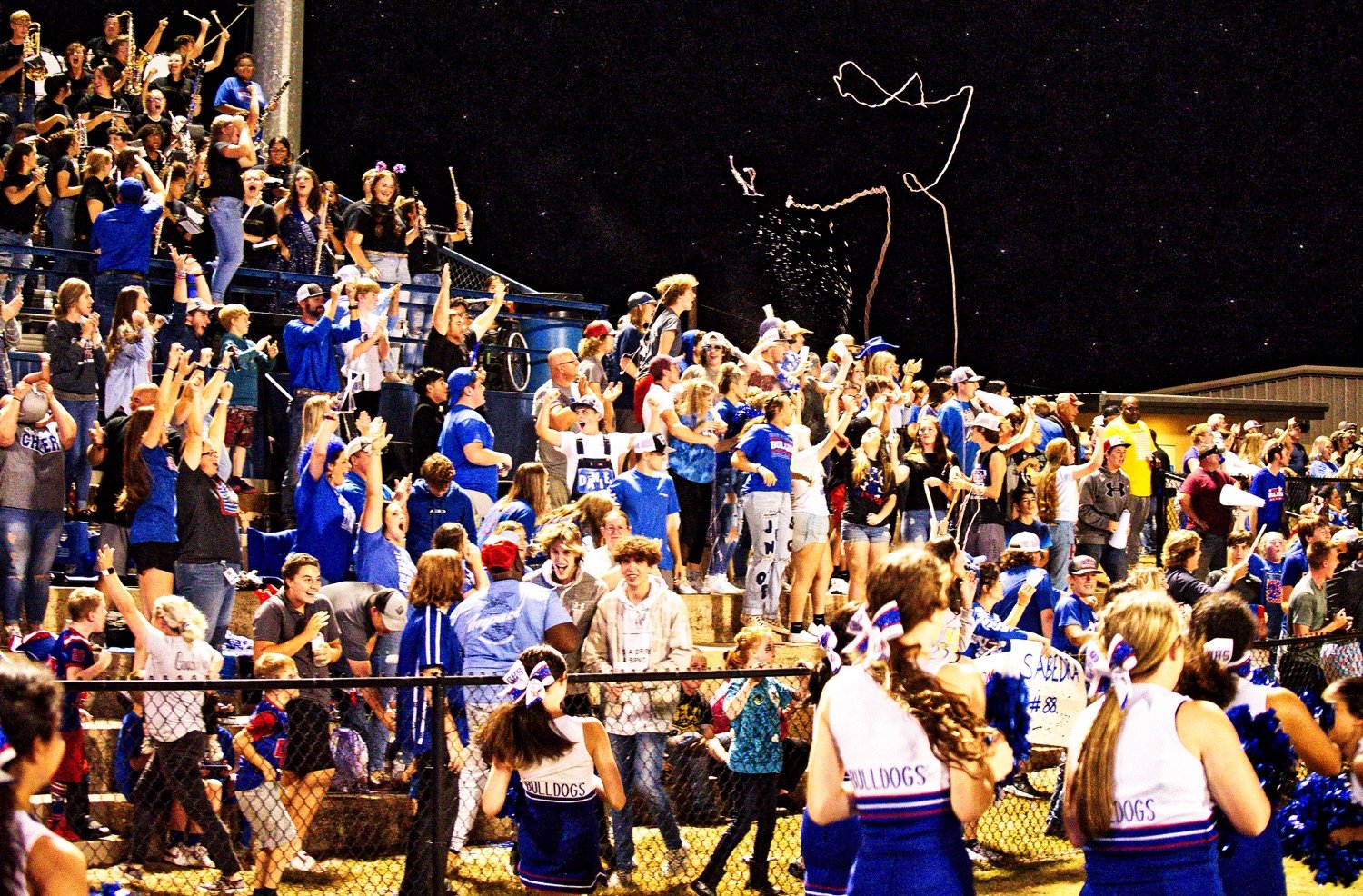 A jubilant student section celebrates a pick-sick, 58-yard interception return by Mikey Pickering. [See more from the Quitman homecoming game.]
